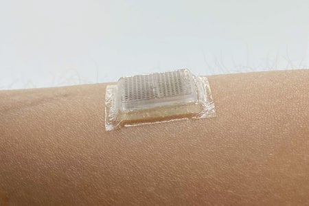 Square device adhered to person's skin