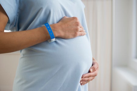 Pregnant woman wearing hospital gown