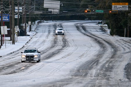 Cars driving on snowy highway.