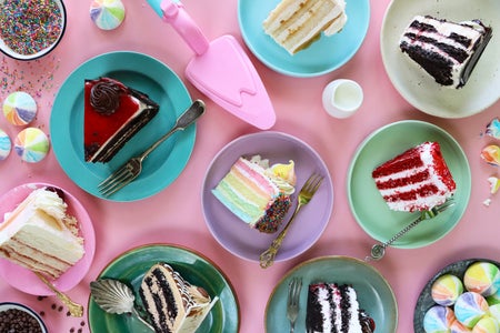 Close-up image of cake slice varieties on multicoloured plates