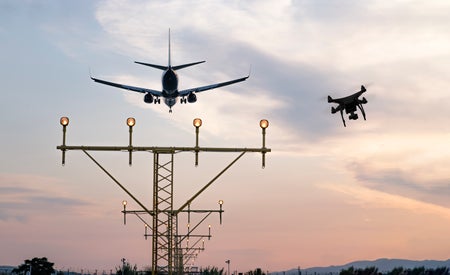 Drone flying at the airport near an aircraft