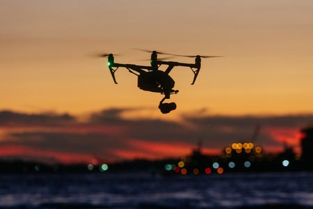 Drone flying in front of New York skyline at sunset