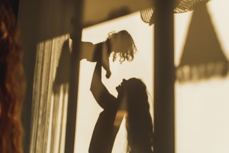 Shadow on wall of mom holding baby