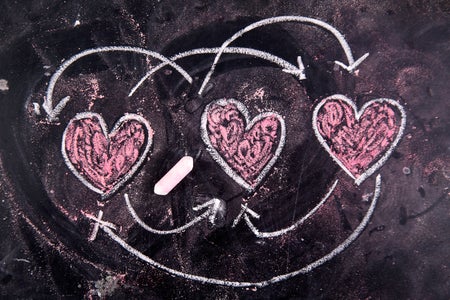 Three hearts drawn on a chalkboard with arrows connecting them in various combinations