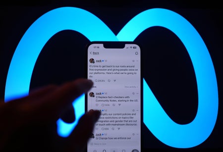 Meta Logo Background with iphone showing Zuckergerg posts.