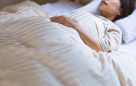 Woman sleeping in white sheets