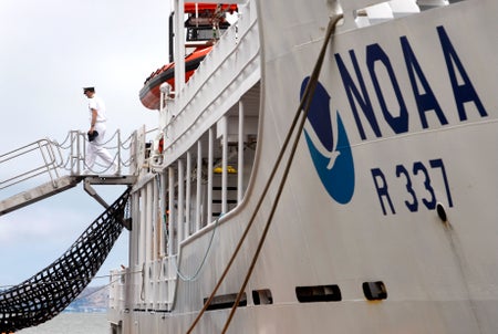 A commander walking off the The NOAA Okeanos Explorer.