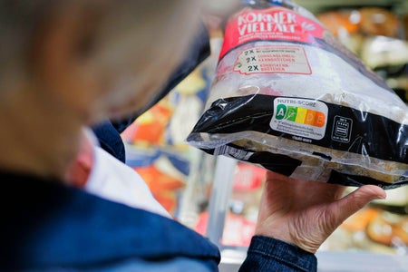 Person holding product to read Nutri-Score label in a German grocery store