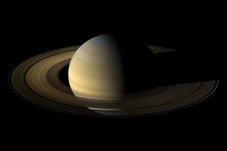 Image captured by Cassini of Saturn, from 20 degrees above the ring plane, showing its rings, and a few of its moons a day and a half after exact Saturn equinox, when the sun's disk was exactly overhead at the planet's equator. At equinox, the shadows of the planet's expansive rings are compressed into a single, narrow band cast onto the plane