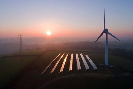 Solar panels and wind turbines in field