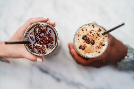 Close up of two hands holding Iced Americano and Latte